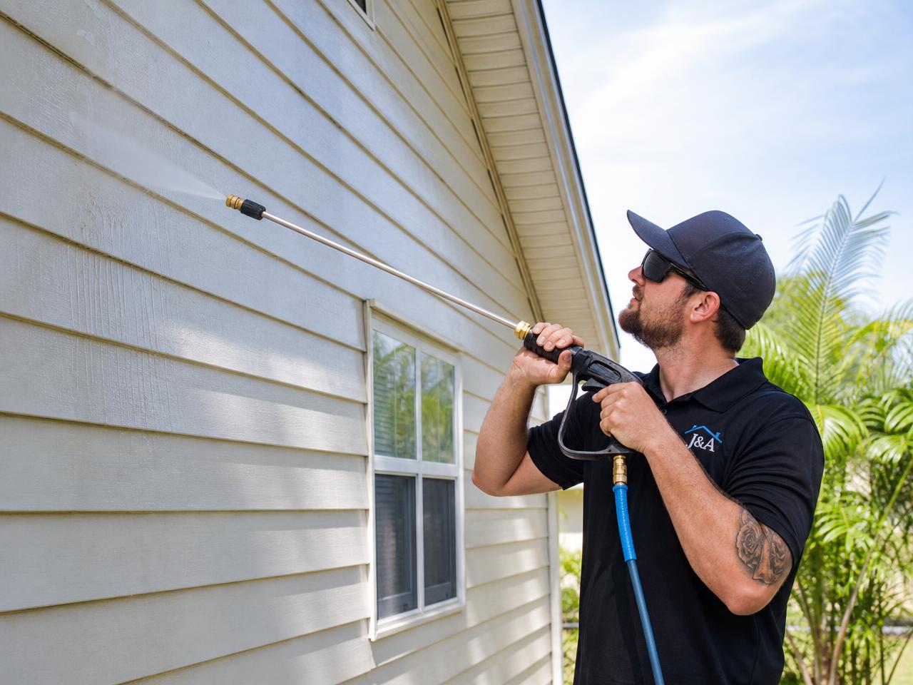 Soft washing house siding with an extension wand